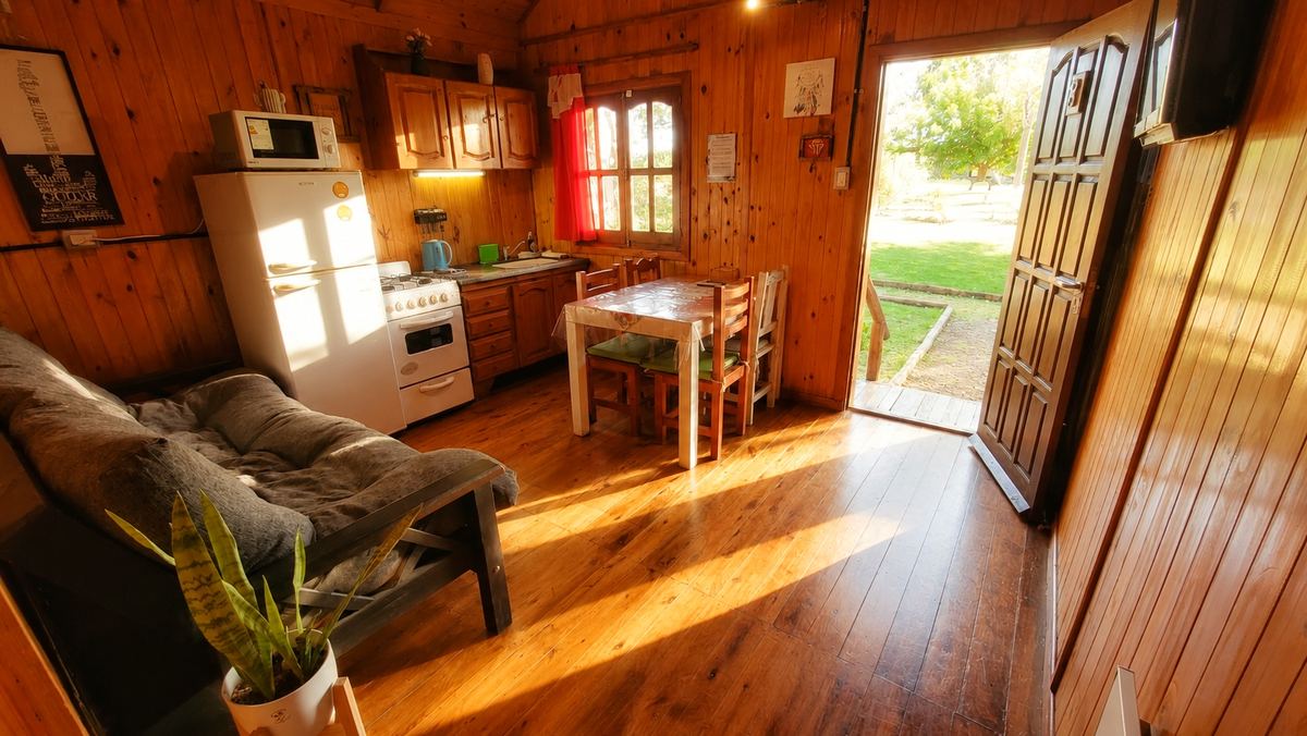 El estar, con la cocina y la puerta al parque